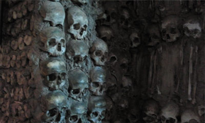 Foto do detalhe de um pilar, decorado com crânios