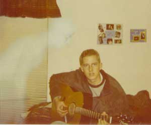 Foto de um rapaz tocando violão e um suposto fantasma ao seu lado